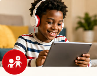 Un enfant au casque suit un cours d’anglais sur sa tablette.